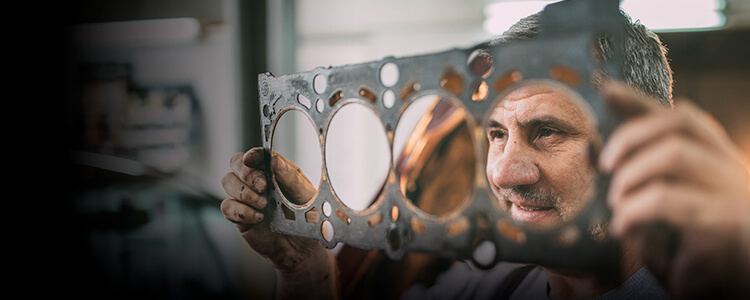 Smiling male mechanic holding car part