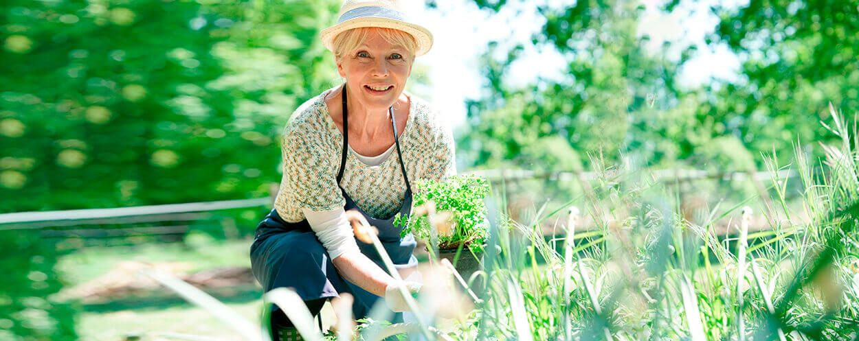 Elderly woman smiling while gardening